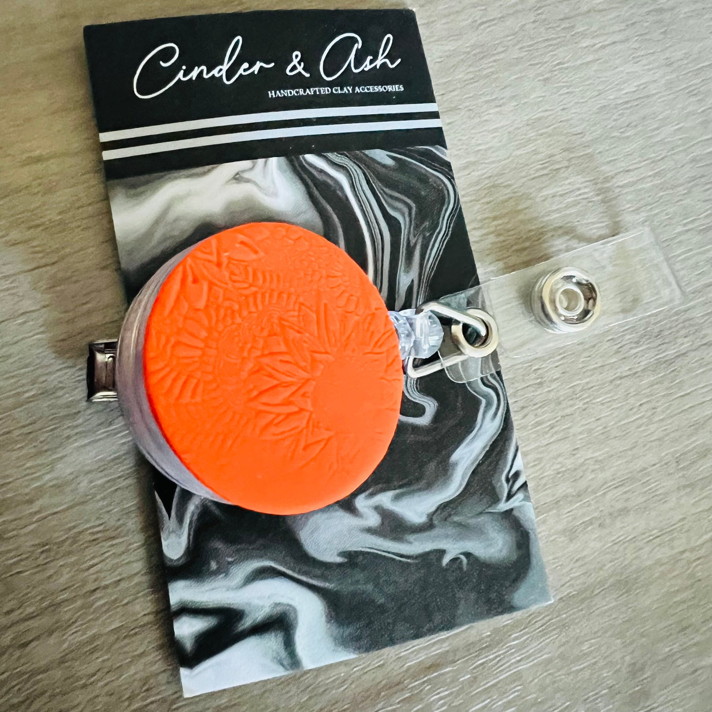 ORANGE FLORAL IMPRINT BADGE REEL - cinder.and.ash